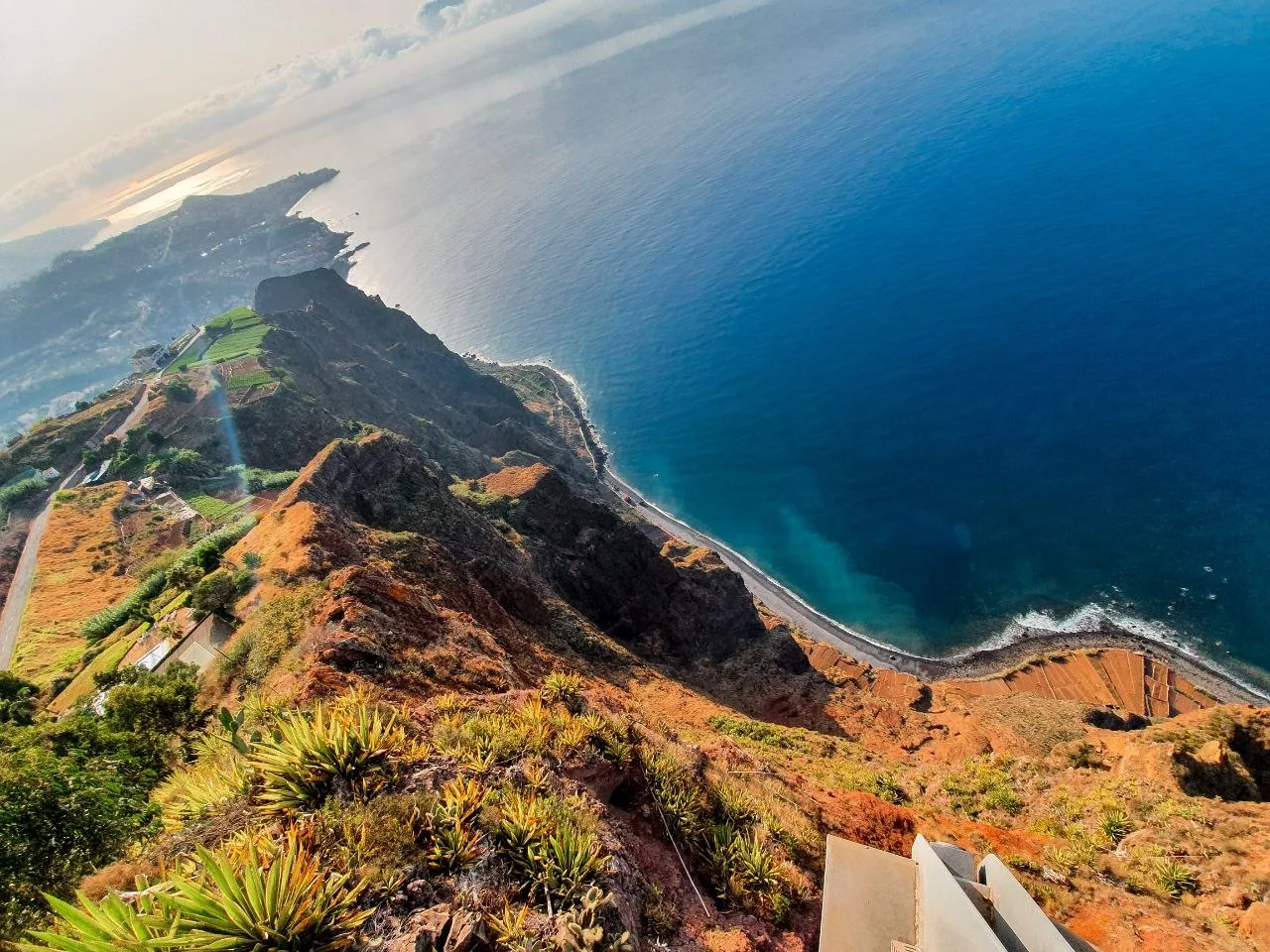 The Cabo Girão skywalk platform at the cliff edge, with agave plants and the coastline far below, Madeira
